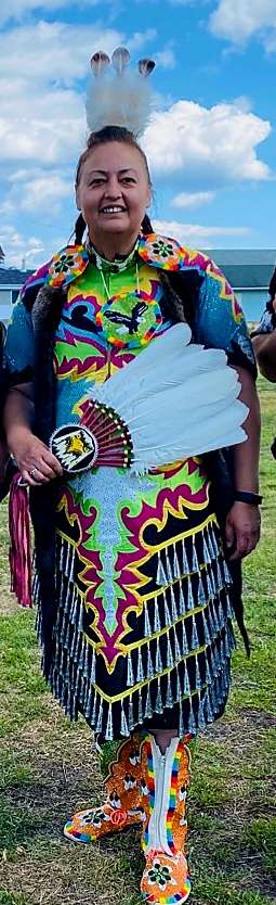 La photo présente Annick Wylde dans ses habits de dance traditionnels Abitibiwinni. Ces habits sont issus des méthodes de l'artisanat ancestral. 